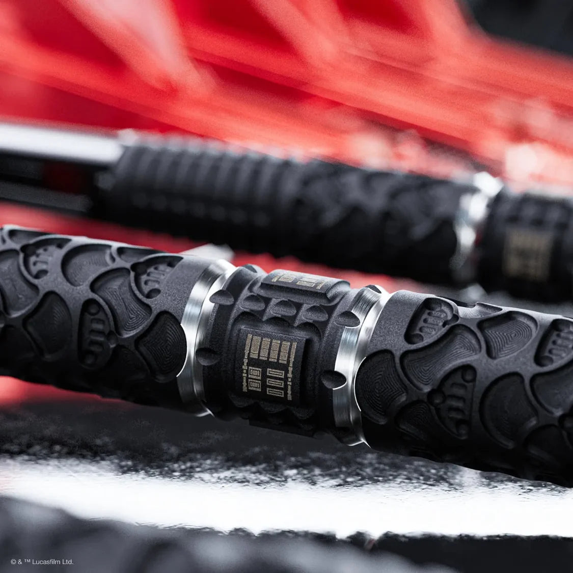 Close-up of a black dart with a blurred red background