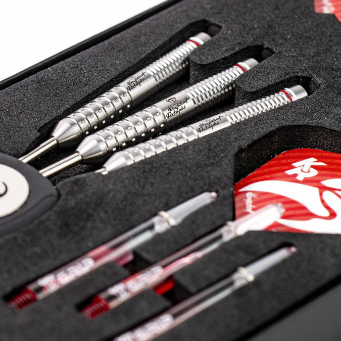 Angled close-up of 90% tungsten darts set in protective foam case showing ringed grip barrels, shafts, and red flights