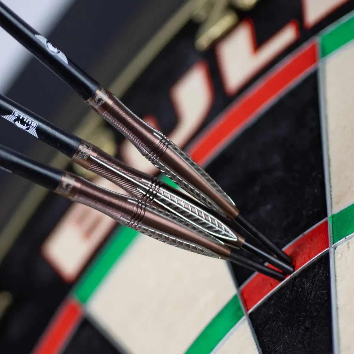 Three 90% tungsten darts grouped in red double segment, close-up of knurled barrel grip and precision on dartboard