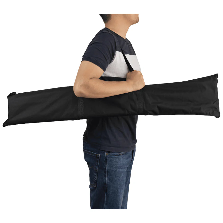 Darts travel stand in black carry bag with shoulder strap, shown carried by person for size and portability reference