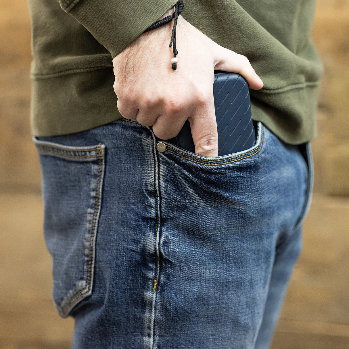 Darts case pocket-sized for easy carrying, shown in hand and fitting into jeans pocket, ideal for compact dart equipment storage