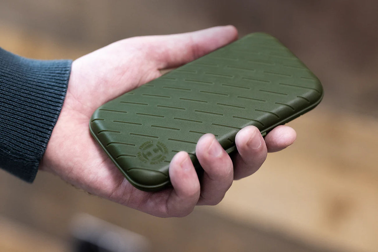 Olive green slim darts case with textured grip shown in hand for scale, durable dart storage accessory
