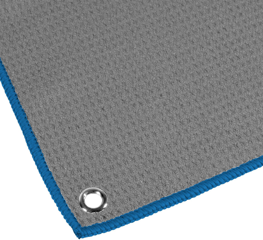 Close-up of waffle hand towel corner with blue trim and metal eyelet, textured fabric for darts accessories