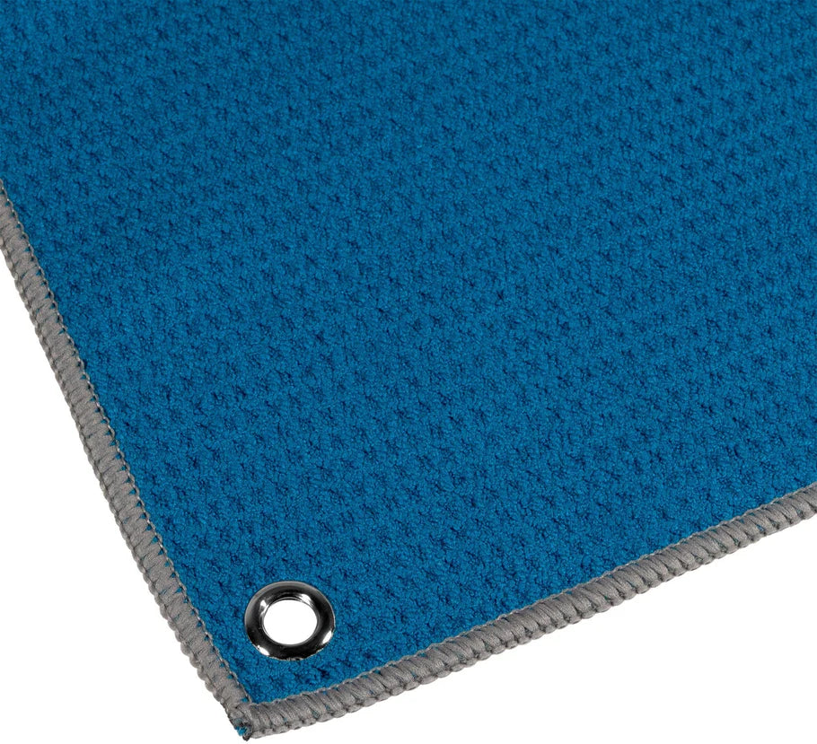 Close-up angled view of blue waffle hand towel corner with textured fabric, grey stitched edge, and grommet for darts accessories