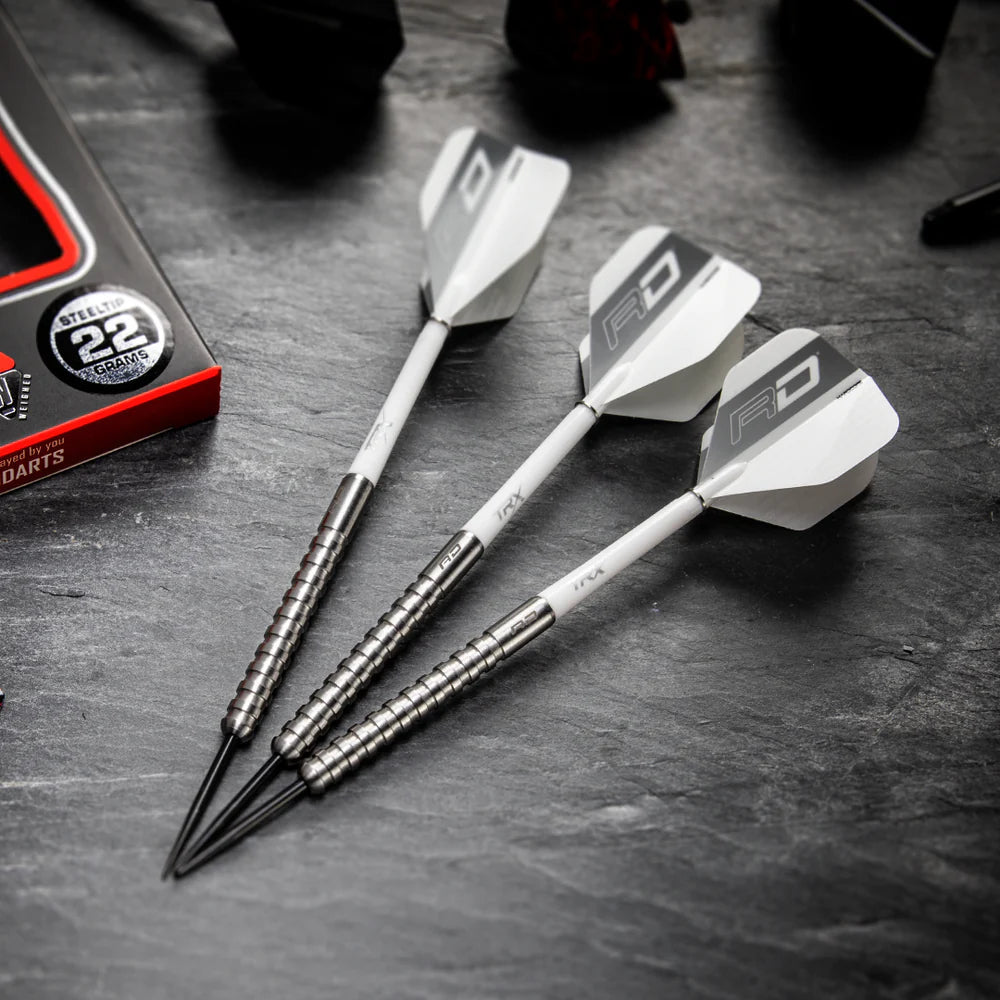 Three 85% tungsten darts with ringed grip barrels and white flights shown angled on black surface, close to packaging for size reference