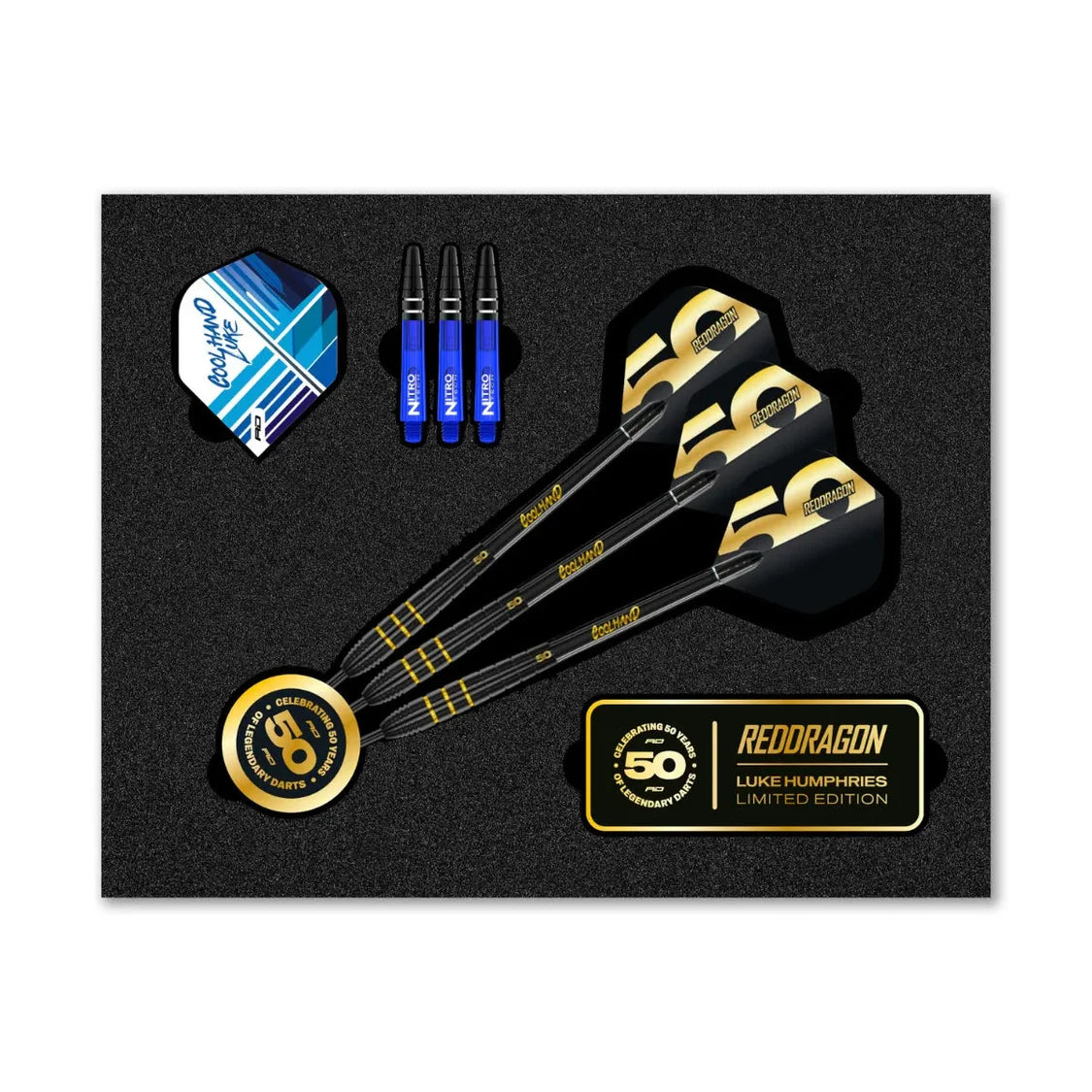 Top-down shot of Luke Humphries 50 Year Anniversary 90% tungsten darts set in display packaging with flights, blue stems, and gold detailing.