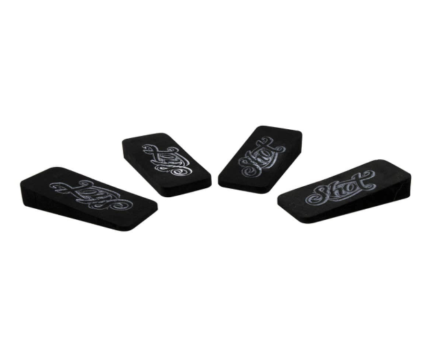 Set of four black dartboard foam wedges angled on white background, highlighting wedge thickness and engraved dart accessory logo