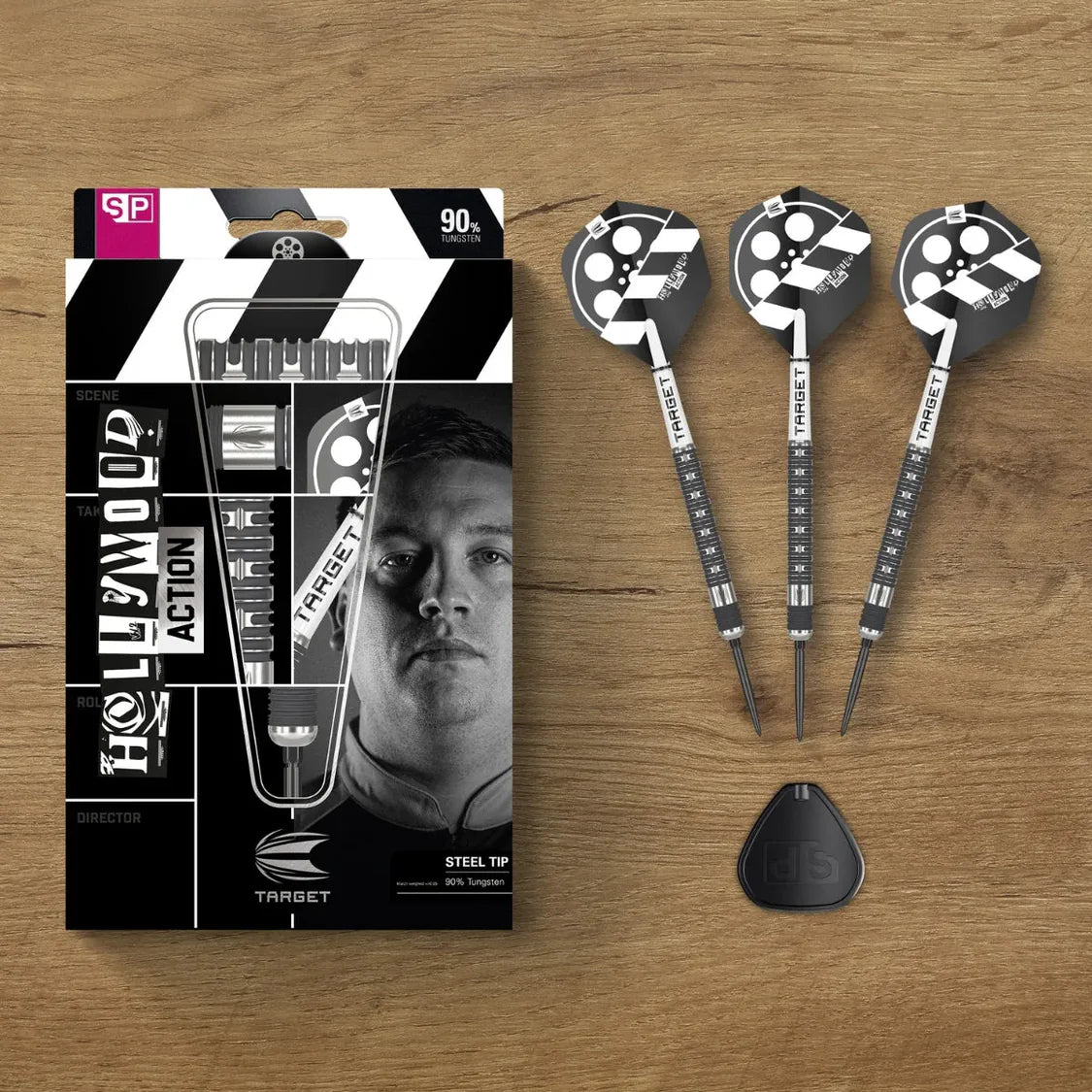 Three 90% tungsten steel tip darts fully assembled beside packaging, showing black and white flights and grip detail on wood background.