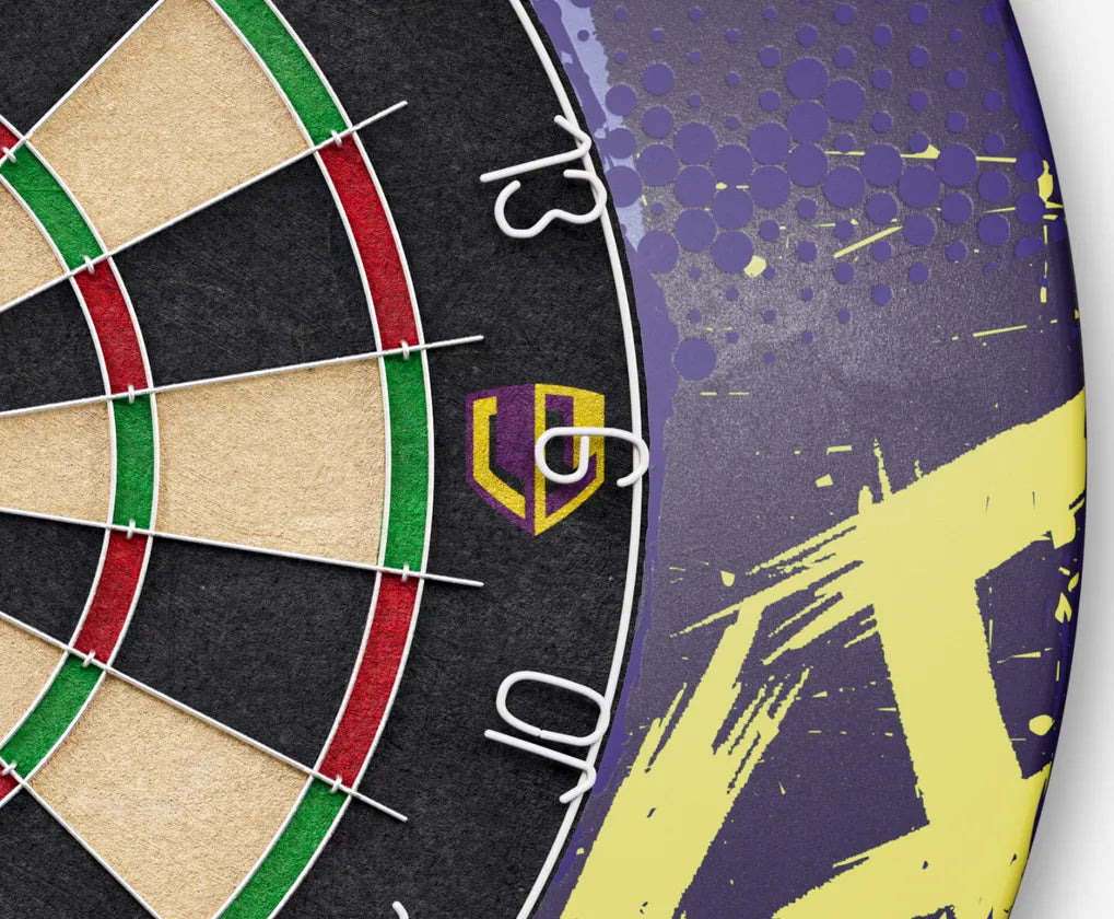 Close-up of dartboard with purple and yellow Luke Littler surround, highlighting logo, wired numbers, and textured protective ring