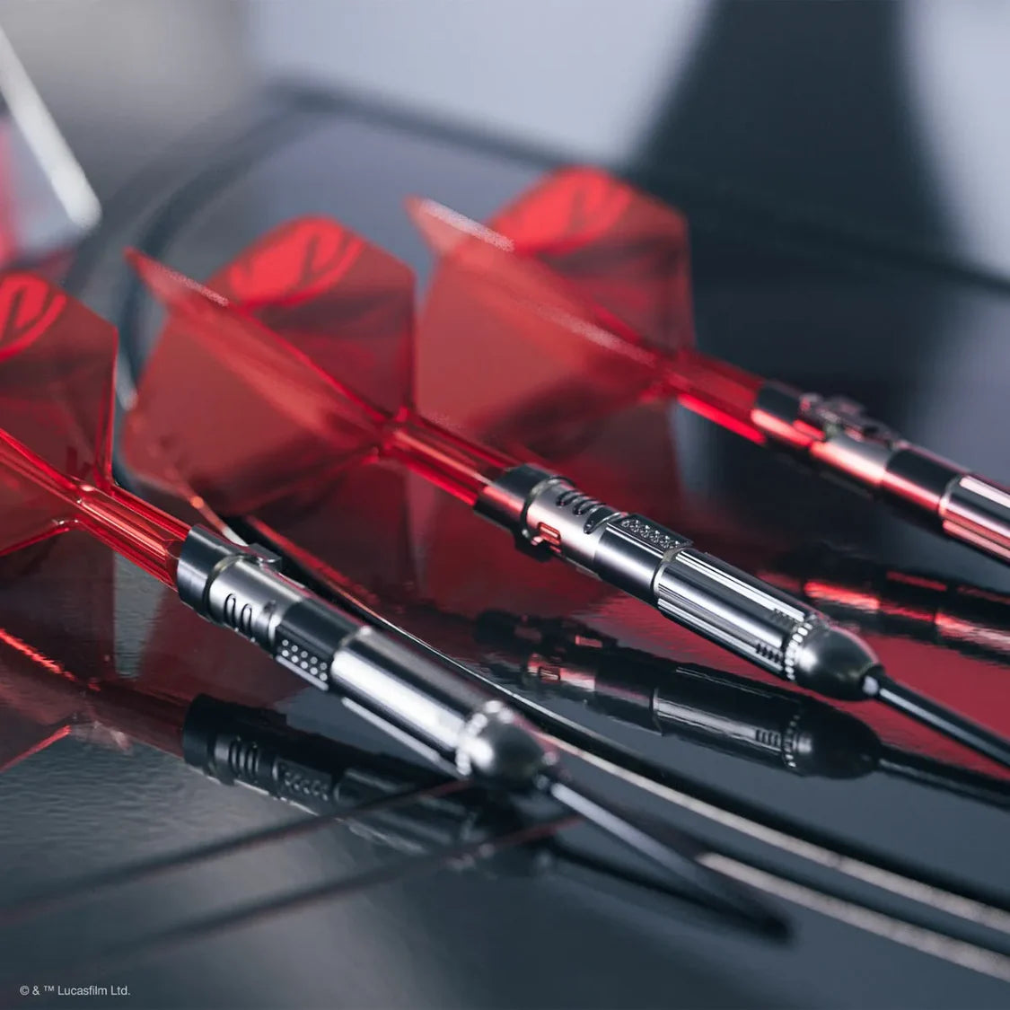 Angled close-up of three Darth Vader lightsaber darts with detailed barrels and red flights, arranged on reflective surface for collectors