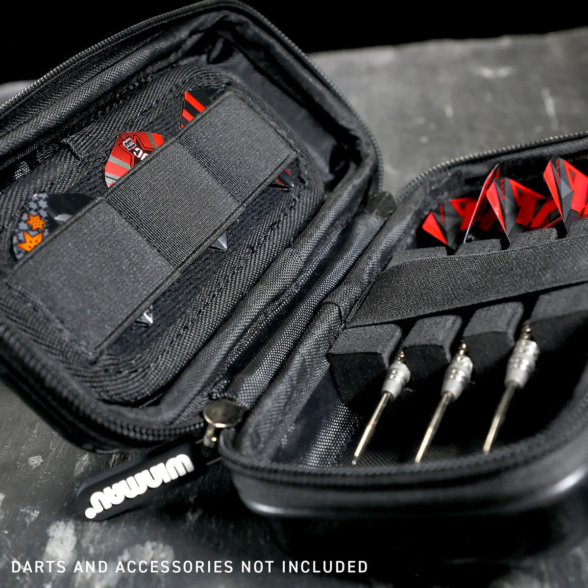 Angled close-up of open red darts case with foam slots for darts, organized interior, and elastic bands for flights and accessories