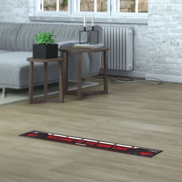 Dart oche throw line mat positioned on wood floor in man cave living room setup