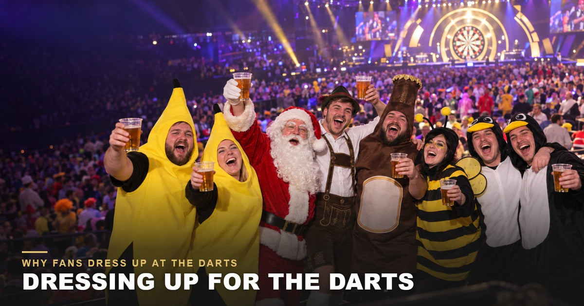 Darts fans in fancy dress, including banana, Santa, lederhosen, beer bottle, bumblebee and penguin costumes, cheering in the crowd at a darts night