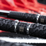 Close-up of a black dart with a blurred red background