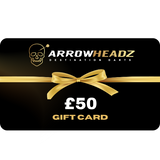 £50 ArrowHeadz darts gift card with gold ribbon bow, flat lay presentation on black background