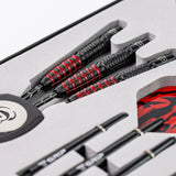 Angled close-up of tungsten darts in display packaging with black and red grip zones and detailed barrel texture