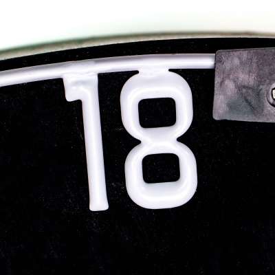 Close-up of dartboard replacement number ring showing metal 18 digit on black background for dartboard accessories