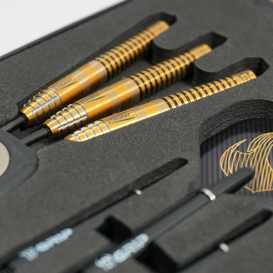 Close-up angled view of three 90% tungsten darts with gold grip barrels in foam packaging, showcasing Stingray ST3 dart barrel texture.