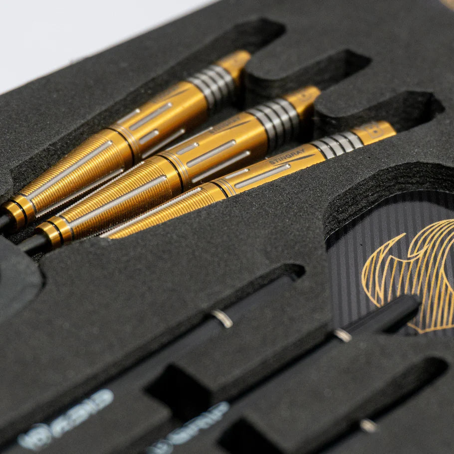 Angled close-up of three gold 90% tungsten darts with precision grooved barrels in foam case, includes flights and shafts for dart players.