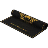 Angled view of a partially unrolled darts mat with oche line, gold edge design, and durable carpet surface for dart throw area