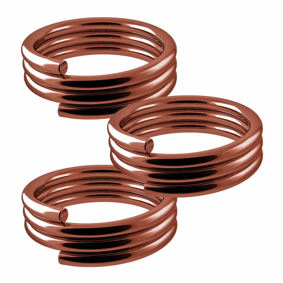 Close-up of three metallic dart spring O-rings for nylon shafts, isolated on white background, showing coiled design and smooth finish