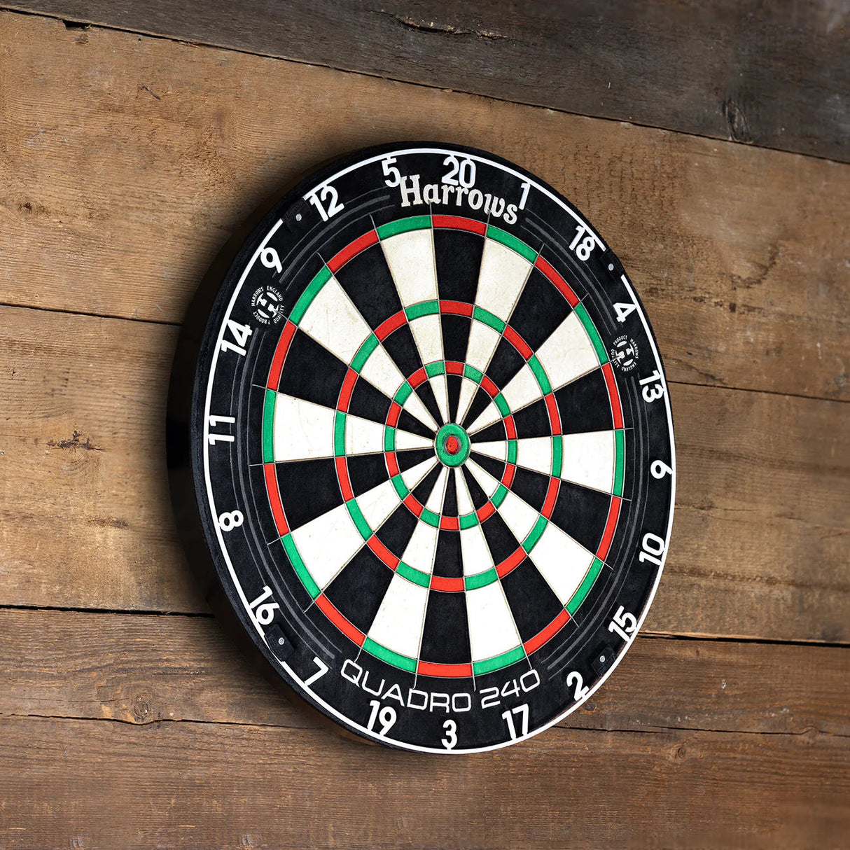 Quadro 240 dartboard angled view mounted on wood wall, distinctive quad scoring zones with vibrant red, green, black, and white sections