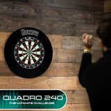 Dartboard mounted on wooden wall with person aiming to throw, full view, ideal for dart game setup and recreational play