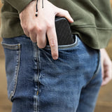 Slim darts case pocketable size, textured black finish, shown fitting easily in jeans pocket for portable dart storage