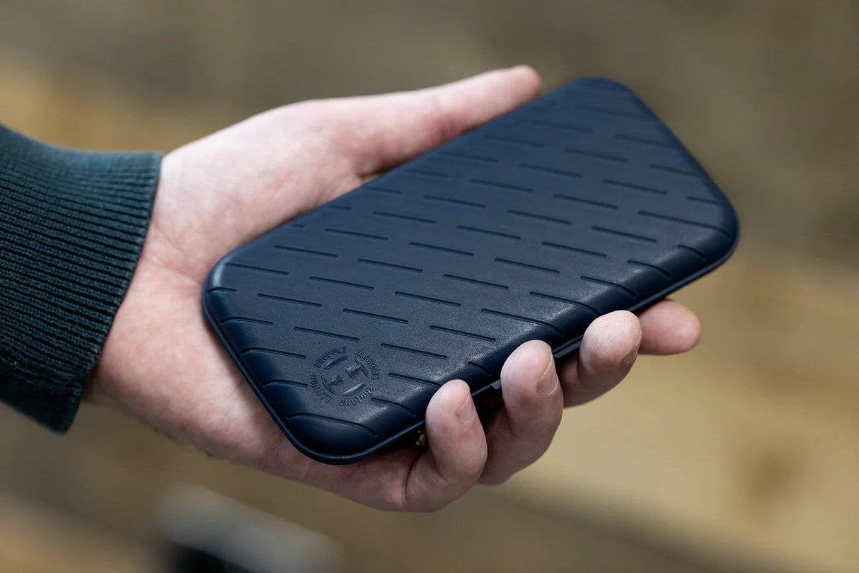 slim darts case with textured black exterior shown in hand for size reference, protective dart case design