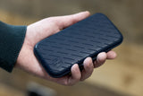 slim darts case with textured black exterior shown in hand for size reference, protective dart case design