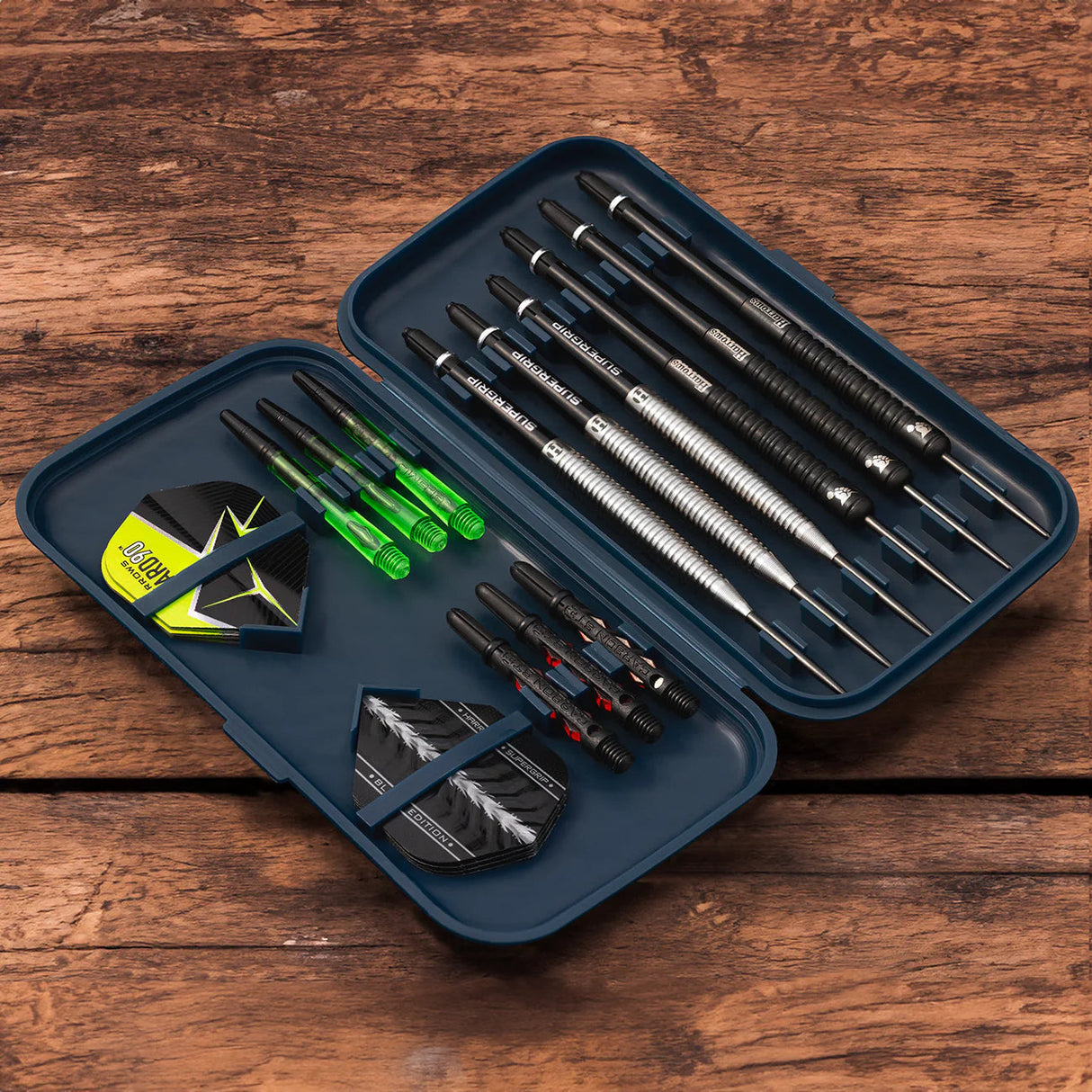 Open darts case top-down view with six darts, spare shafts, flights, and organized dart accessories for secure dart storage