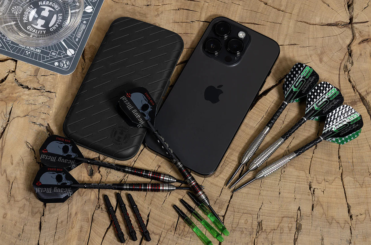 Slimcase darts case top-down beside three assembled darts, extra dart tips, and smartphone for scale on wooden surface