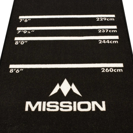 Close-up angled view of darts mat showing oche distance markings in inches and centimeters for dartboard setup