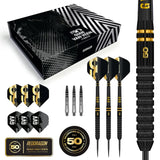 Limited edition 90% tungsten darts set with three black-gold darts, flights, shafts, accessories, and anniversary gift box on white background