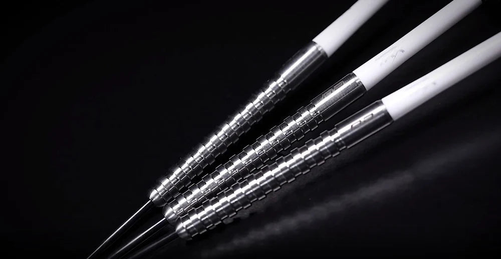 Close-up angled view of three 85% tungsten darts showing grooved ring grip barrels and white shafts, isolated on black background