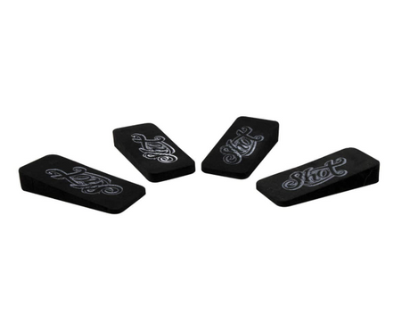 Set of four black dartboard foam wedges angled on white background, highlighting wedge thickness and engraved dart accessory logo