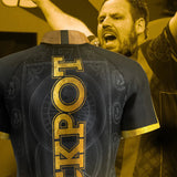Back view of Adrian Lewis 2025 dart shirt with large gold JACKPOT lettering, ornate black pattern, gold sleeve trim, dart player celebrating
