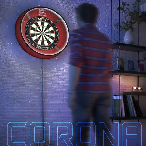 Lifestyle view of dartboard with Corona Vision light illuminating the playing area, wall-mounted in a home setting, person approaching