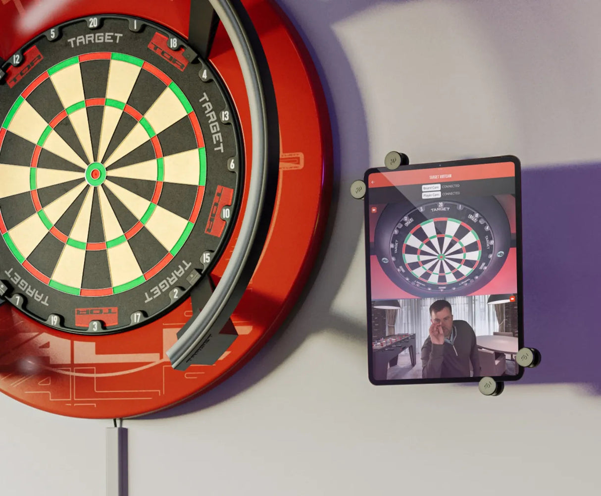 Angled view of electronic dartboard with integrated auto-scoring ring and wall-mounted tablet showing scoring interface for darts