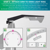 Angled instructional view of Omni Virt Arm attaching to dartboard light ring, showing mounting positions and bracket installation guides for setup.