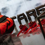 Angled lifestyle shot showing three red Darth Maul K-Flex dart shafts with matching flights, arranged on reflective surface for collectible dart set.