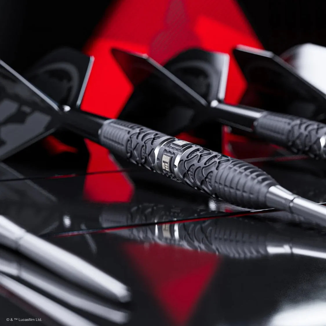 Angled close-up of Star Wars Darth Vader tungsten darts emphasizing textured barrel grip, laser-etched detail, and black flights