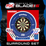 Professional dartboard surround set with Blade 6 dartboard, blue PDC surround, three darts, oche line, and checkout table, isolated on black.